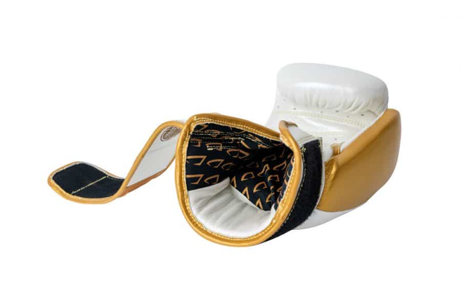 Corbetti CTG-005 Pearl White - Gold, Muay Thai glove, laying down on fist side with the opening facing front highlighting the inner liner