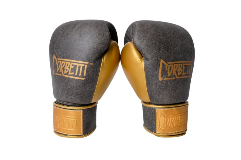 Corbetti CTG-006 Vintage-Gold Muay Thai Gloves both standing up at and angle, fist side forward, to showcase the metallic gold thumbs and brand's logos
