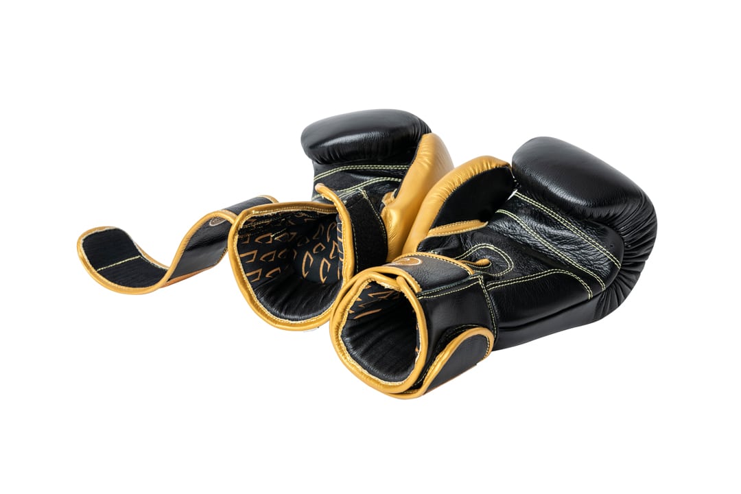 Corbetti CTG-001 Black-Gold Muay Thai Gloves laying fist side down showing a sneak peak of the gloves inner liner