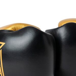 Corbetti CTG-001 Black-Gold Muay Thai Gloves laying on their sides touching fists in a fist forward close up shot highlighting the leather grain
