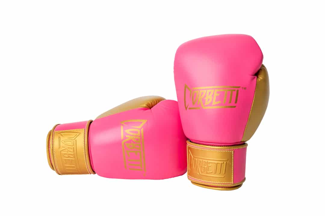 Corbetti CTG-004 Pink-Gold Muay Thai Gloves right laying on its side and left standing up fist side forward showcasing brand's logos