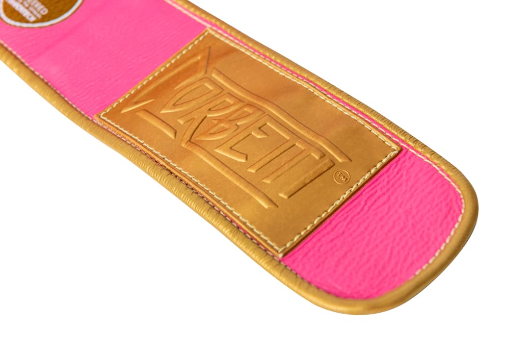 Corbetti CTG-004 Pink-Gold Muay Thai Glove's wrist strap showcasing the gold rubber wrist label
